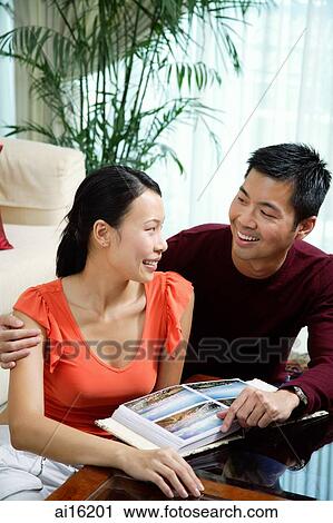 Couple at home, photo album in front of them View Large Photo Image Stock Image - Couple at home, photo album in front of them. Fotosearch
