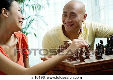 Stock Photograph - Couple at home, playing chess. Fotosearch