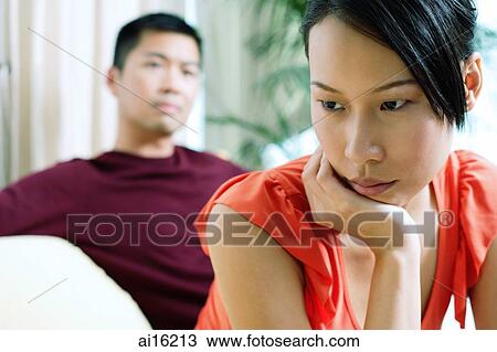 Couple at home, woman in front, looking away, hand on chin View Large Photo Image Stock Image - Couple at home, woman in front, looking away, hand on chin. Fotosearch