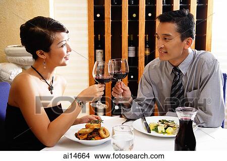 Couple dining out, raising wine glass for a toast View Large Photo Image Picture - Couple dining out, raising wine glass for a toast. Fotosearch