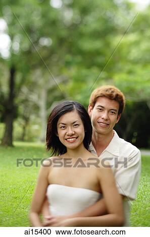 Couple embracing, looking at camera View Large Photo Image Stock Image - Couple embracing, looking at camera. Fotosearch
