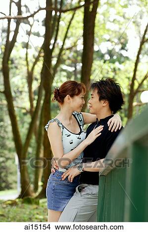 Picture - Couple embracing, looking at each other, outdoor location. Fotosearch