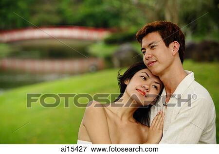 Stock Photo - Couple embracing, woman leaning on mans chest. Fotosearch