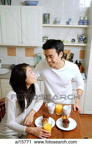 Couple having breakfast in kitchen, smiling at each other View Large Photo Image Stock Image - Couple having breakfast in kitchen, smiling at each other. Fotosearch