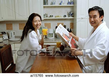 Couple having breakfast, smiling at camera, man holding newspaper View Large Photo Image Stock Photography - Couple having breakfast, smiling at camera, man holding newspaper. Fotosearch
