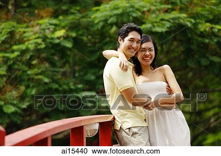 Couple hugging each other, smiling at camera View Large Photo Image Stock Image - Couple hugging each other, smiling at camera. Fotosearch