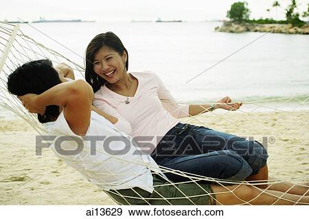 Couple in hammock on beach, talking View Large Photo Image Stock Photo - Couple in hammock on beach, talking. Fotosearch