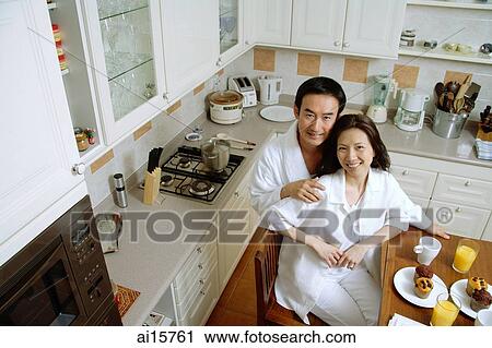Couple in kitchen, smiling at camera, high angle view View Large Photo Image Stock Image - Couple in kitchen, smiling at camera, high angle view. Fotosearch