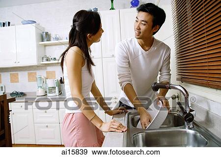 Couple in kitchen, washing dishes View Large Photo Image Stock Photo - Couple in kitchen, washing dishes. Fotosearch
