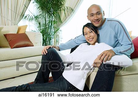 Couple in living room, smiling at camera, portrait View Large Photo Image Stock Image - Couple in living room, smiling at camera, portrait. Fotosearch