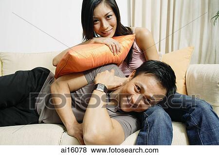 Couple in living room, woman lying on mans lap, smiling at camera View Large Photo Image Stock Photo - Couple in living room, woman lying on mans lap, smiling at camera. Fotosearch