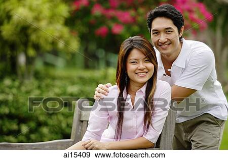 Stock Photo - Couple in park, looking at camera. Fotosearch