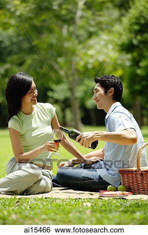 Couple in park, man pouring wine for woman View Large Photo Image Stock Photograph - Couple in park, man pouring wine for woman. Fotosearch
