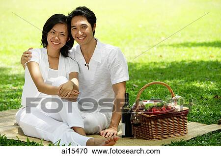 Couple in park, sitting with picnic basket, smiling at camera View Large Photo Image Stock Image - Couple in park, sitting with picnic basket, smiling at camera. Fotosearch