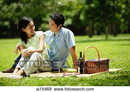 Couple in park, sitting with picnic basket, portrait View Large Photo Image Stock Photo - Couple in park, sitting with picnic basket, portrait. Fotosearch