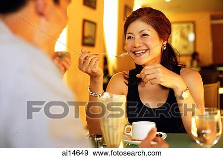 Stock Photo - Couple in restaurant, eating sundae. Fotosearch