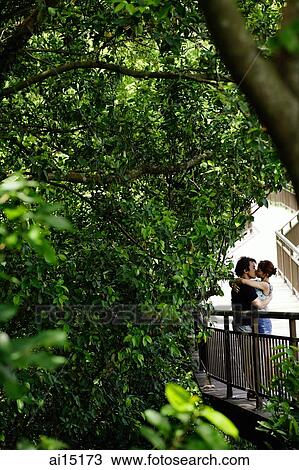 Stock Image - Couple kissing in park. Fotosearch
