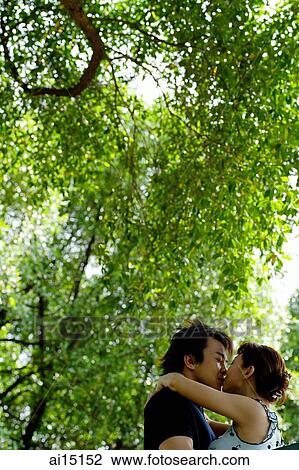 Stock Image - Couple kissing, outdoor location. Fotosearch