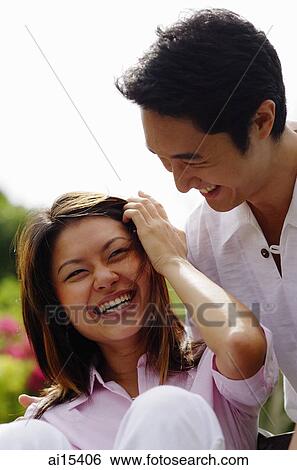Couple laughing, woman touching her hair View Large Photo Image Stock Photograph - Couple laughing, woman touching her hair. Fotosearch