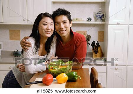 Couple leaning on kitchen counter, smiling at camera View Large Photo Image Stock Photography - Couple leaning on kitchen counter, smiling at camera. Fotosearch