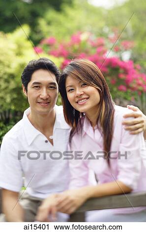Couple looking at camera, man with arm around woman View Large Photo Image Stock Image - Couple looking at camera, man with arm around woman. Fotosearch
