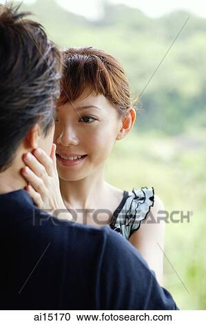 Couple looking at each other, woman with hand on man's face View Large Photo Image Stock Image - Couple looking at each other, woman with hand on man's face. Fotosearch
