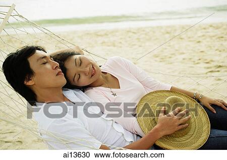 Couple lying in hammock on beach, eyes closed View Large Photo Image Stock Image - Couple lying in hammock on beach, eyes closed. Fotosearch