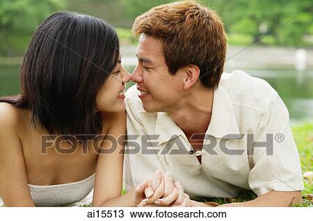 Couple lying on grass, face to face, noses touching View Large Photo Image Stock Image - Couple lying on grass, face to face, noses touching. Fotosearch