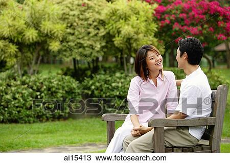 Couple on park bench, looking at each other View Large Photo Image Stock Image - Couple on park bench, looking at each other. Fotosearch
