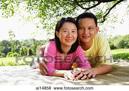 Couple on picnic mat, looking at camera View Large Photo Image Stock Photo - Couple on picnic mat, looking at camera. Fotosearch