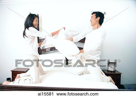 Stock Image - Couple pillow fighting. Fotosearch