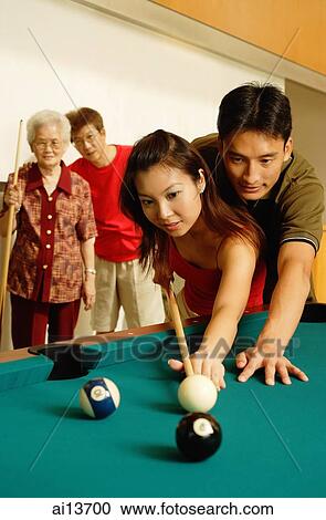 Couple playing pool, father and grandmother looking on View Large Photo Image Stock Image - Couple playing pool, father and grandmother looking on. Fotosearch