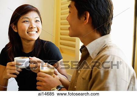 Couple sitting, holding coffee cups, side by side View Large Photo Image Stock Photography - Couple sitting, holding coffee cups, side by side. Fotosearch
