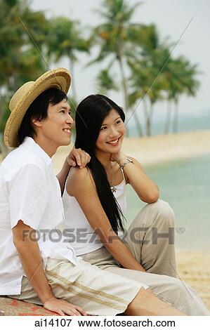 Couple sitting on beach, looking away View Large Photo Image Stock Photo - Couple sitting on beach, looking away. Fotosearch