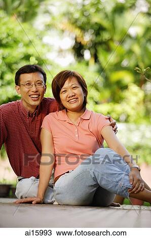 Couple sitting on floor, looking at camera View Large Photo Image Stock Image - Couple sitting on floor, looking at camera. Fotosearch