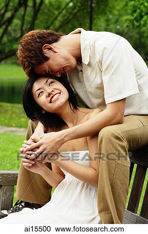 Couple sitting on park bench View Large Photo Image Stock Image - Couple sitting on park bench. Fotosearch