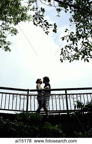 Couple standing face to face, low angle view View Large Photo Image Stock Photo - Couple standing face to face, low angle view. Fotosearch