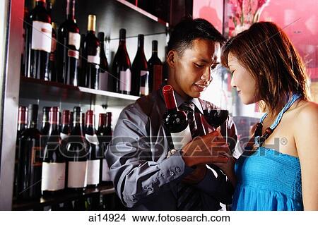 Couple standing face to face, man holding wine glass View Large Photo Image Picture - Couple standing face to face, man holding wine glass. Fotosearch