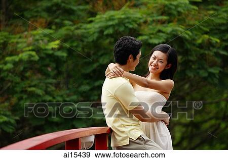 Couple standing face to face on bridge, woman with arms around mans neck View Large Photo Image Stock Photo - Couple standing face to face on bridge, woman with arms around mans neck. Fotosearch