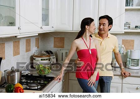 Couple standing in kitchen, smiling at each other, portrait View Large Photo Image Picture - Couple standing in kitchen, smiling at each other, portrait. Fotosearch