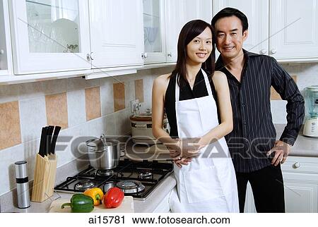 Couple standing in kitchen, smiling at camera View Large Photo Image Stock Image - Couple standing in kitchen, smiling at camera. Fotosearch