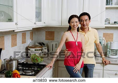 Couple standing in kitchen, smiling at camera, portrait View Large Photo Image Stock Image - Couple standing in kitchen, smiling at camera, portrait. Fotosearch