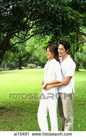 Couple standing, man embracing woman View Large Photo Image Stock Image - Couple standing, man embracing woman. Fotosearch