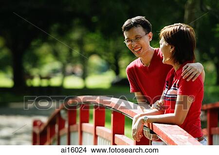 Couple standing on bridge, looking away View Large Photo Image Picture - Couple standing on bridge, looking away. Fotosearch