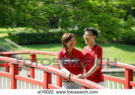 Couple standing on bridge View Large Photo Image Stock Image - Couple standing on bridge. Fotosearch
