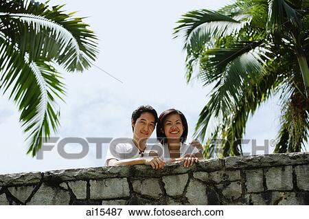 Stock Photo - Couple standing side by side, looking at camera. Fotosearch