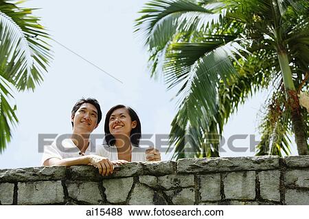 Couple standing side by side, looking away View Large Photo Image Stock Photo - Couple standing side by side, looking away. Fotosearch