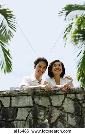 Couple standing side by side, looking away View Large Photo Image Stock Photograph - Couple standing side by side, looking away. Fotosearch
