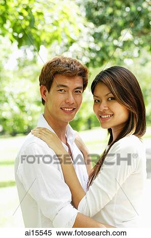 Couple standing together, looking at camera View Large Photo Image Stock Photography - Couple standing together, looking at camera. Fotosearch