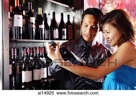 Couple studying bottle of wine View Large Photo Image Stock Photography - Couple studying bottle of wine. Fotosearch